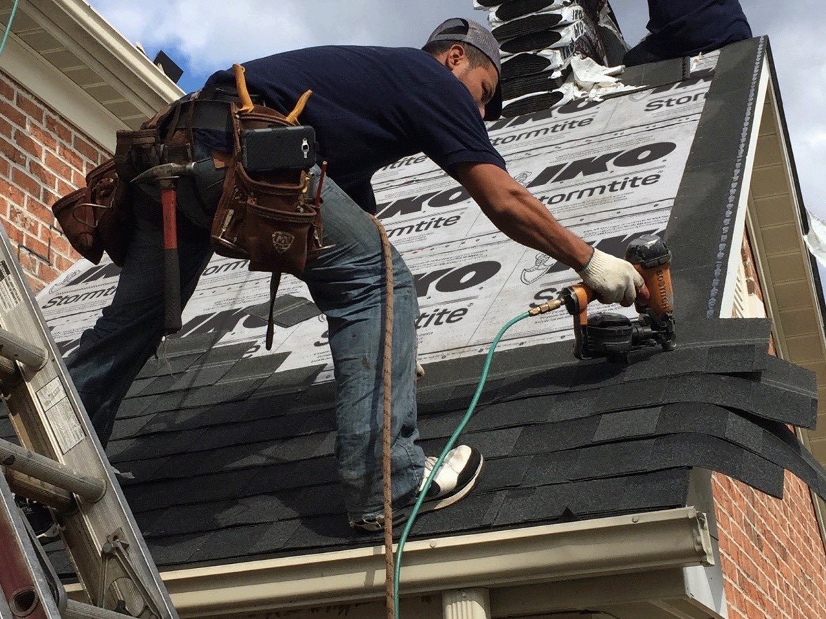 Roofer inspecting shingles and flashing detail